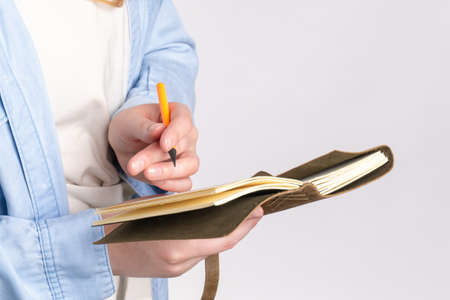 Leather notebook with pencil in hand