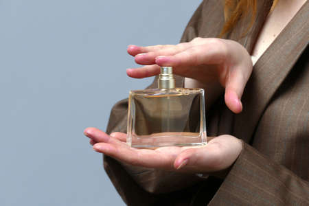 Perfume bottle in beautiful woman hands selective focusの写真素材
