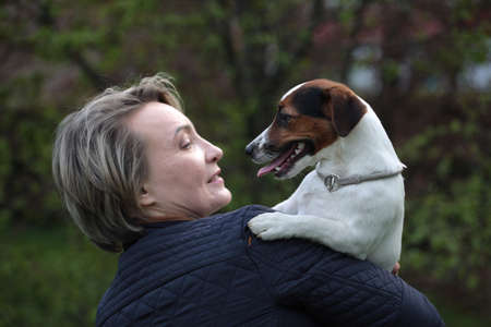 Attractive woman having rest in park with white jack russell terriers. Love story close up portrait