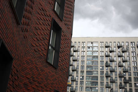 Elements of Exterior of high-rise Red brick apartment building facade, windows and balconies.