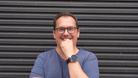 Middle-aged guy with trendy eyeglasses on striped background