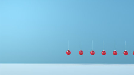 Row of color christmas balls hanging on strings over blue background.の素材