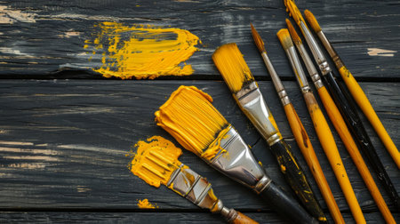 paintbrush and yellow paints on black background.の素材