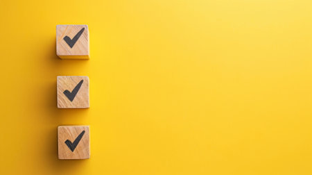 Checklist concept, Check mark on wooden blocks, yellow background with copy space.の素材