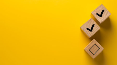 Checklist concept, Check mark on wooden blocks, yellow background with copy space.の素材