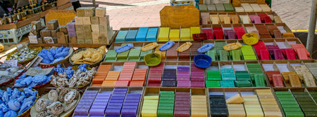 Assortment of colorful handmade soap bars and natural skincare products on display at a traditional French market. Organic cosmetics and artisanal bath products, Provence, France.の写真素材