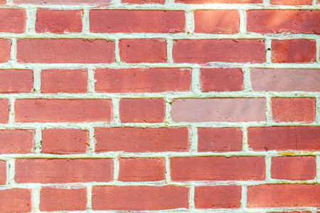 Red brick wall with cement joints and textured masonry. Rough surface for construction,...
