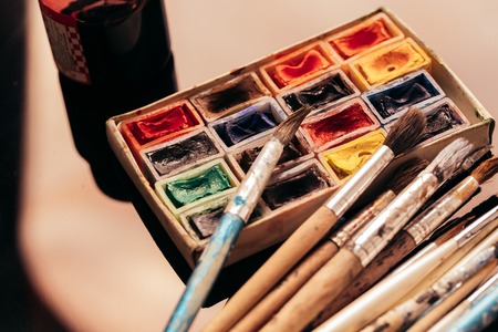 pack of watercolor paints and brush on a dark background.の写真素材