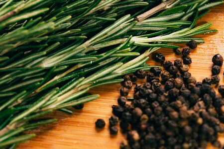 sprig of rosemary and pepper on a wooden light background.の写真素材