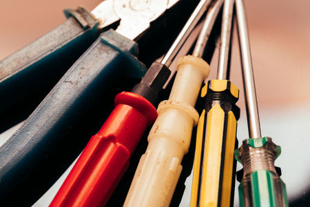many different screwdrivers and pliers on a dark background bunch.の写真素材