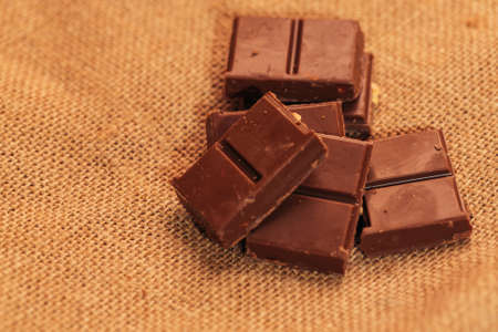 pieces of dark chocolate on sacking background.の写真素材