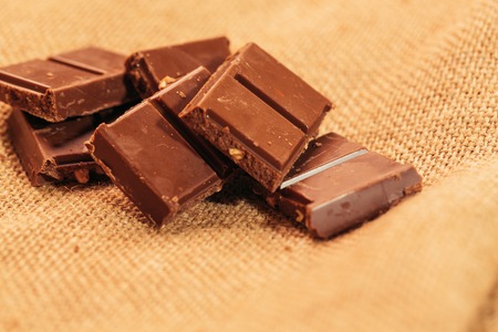 pieces of dark chocolate on sacking background.の写真素材