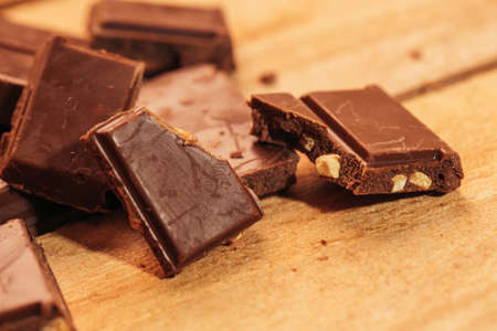 pieces of dark chocolate on a wooden background.の写真素材