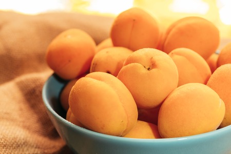 apricots in a bowl on a blurry background.の写真素材