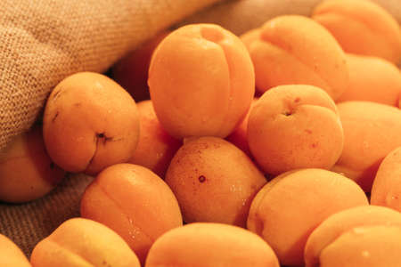 fresh ripe orange apricot closeup on sackcloth background.の写真素材