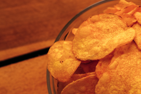 clear bowl of potato chips on a wooden background.の写真素材