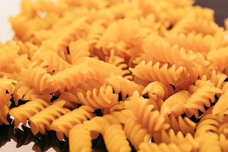 many macaroni scattered on a black background.の写真素材