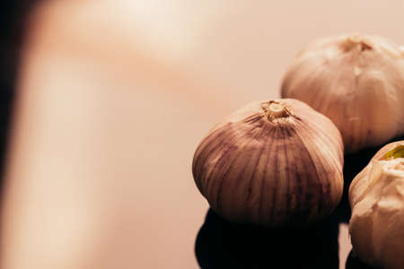 several heads of garlic on a dark mirror background.の写真素材