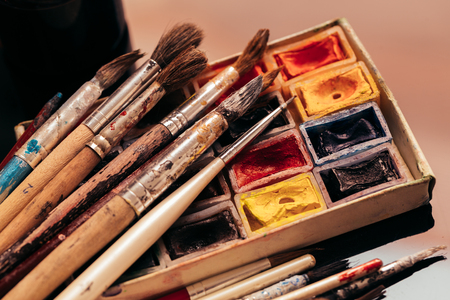 pack of watercolor paints and brush on a dark background.の写真素材