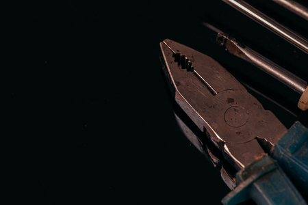 many different screwdrivers and pliers on a dark background bunch.の写真素材