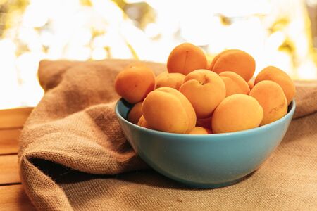 apricots in a bowl on sacking background.の写真素材
