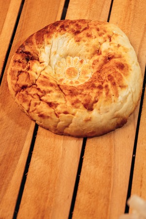 National Uzbek bread on a wooden background, top view.