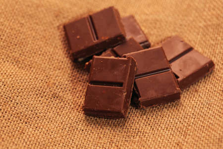 pieces of dark chocolate on sacking background.の写真素材