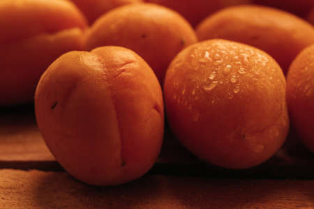 fresh ripe orange apricot closeup on wooden background.の写真素材