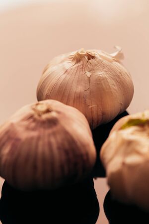 several heads of garlic on a dark mirror background.の写真素材