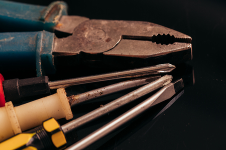 many different screwdrivers and pliers on a dark background bunch.の写真素材