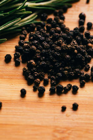 sprig of rosemary and pepper on a wooden light background.の写真素材