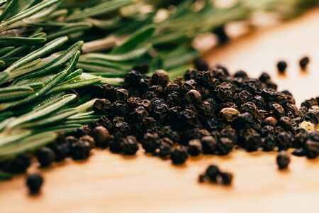 sprig of rosemary and pepper on a wooden light background.の写真素材