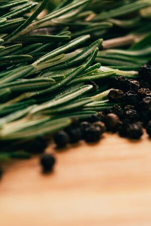 sprig of rosemary and pepper on a wooden light background.の写真素材