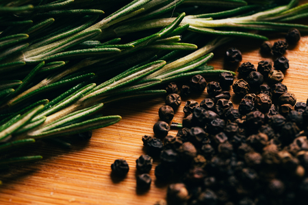 sprig of rosemary and pepper on a wooden light background.の写真素材