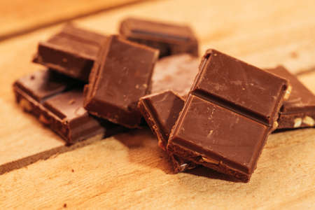 pieces of dark chocolate on a wooden background.の写真素材