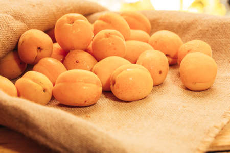 fresh ripe orange apricot closeup on sackcloth background.の写真素材
