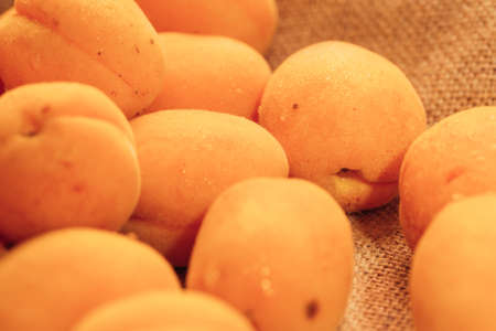 fresh ripe orange apricot closeup on sackcloth background.