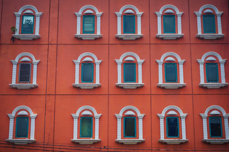 Vintage bright red building with white windowsの写真素材