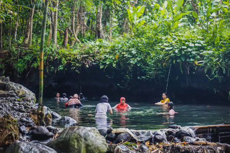 Yogyakarta, Indonesia - December 30, 2018: People swim in the river in the jungle