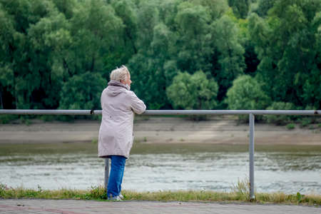 Omsk, Russia - June 28, 2020: Woman resting near the river
