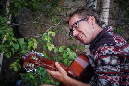 The guy plays the guitar on the Krasnoyarsk pillars at sunset