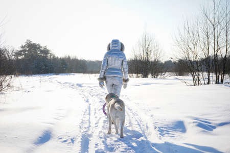 Girl with a white dog in the snow in winterの写真素材
