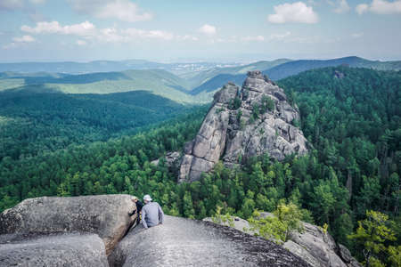 Krasnoyarsk, Russia - July 12, 2020: Guys climb the rocks of the Krasnoyarsk Pillarsのeditorial素材