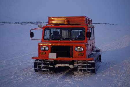 Red caterpillar all-terrain vehicle on a snowy road in Kamchatka