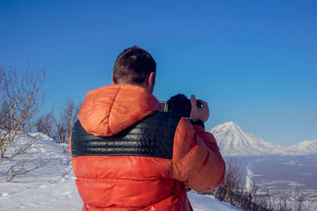 The guy takes pictures of volcanoes in Kamchatka peninsula in Russiaの写真素材