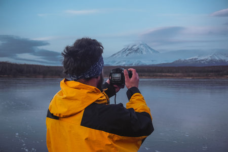A Man Taking Photos of Mountains at sunsetの写真素材
