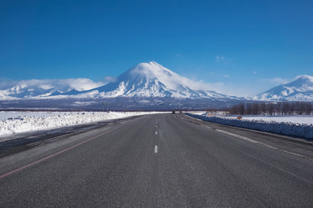 Road and view to Koryaksky Volcano in Kamchatka peninsula in Russiaの写真素材