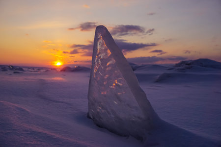 Ice floes on the snow at sunset