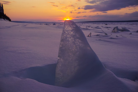 Ice floes on the snow at sunset