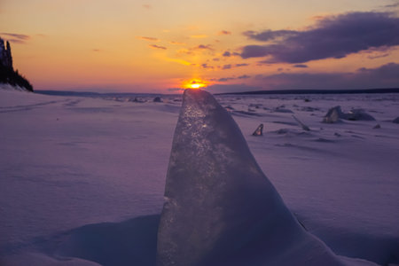 Ice floes on the snow at sunset